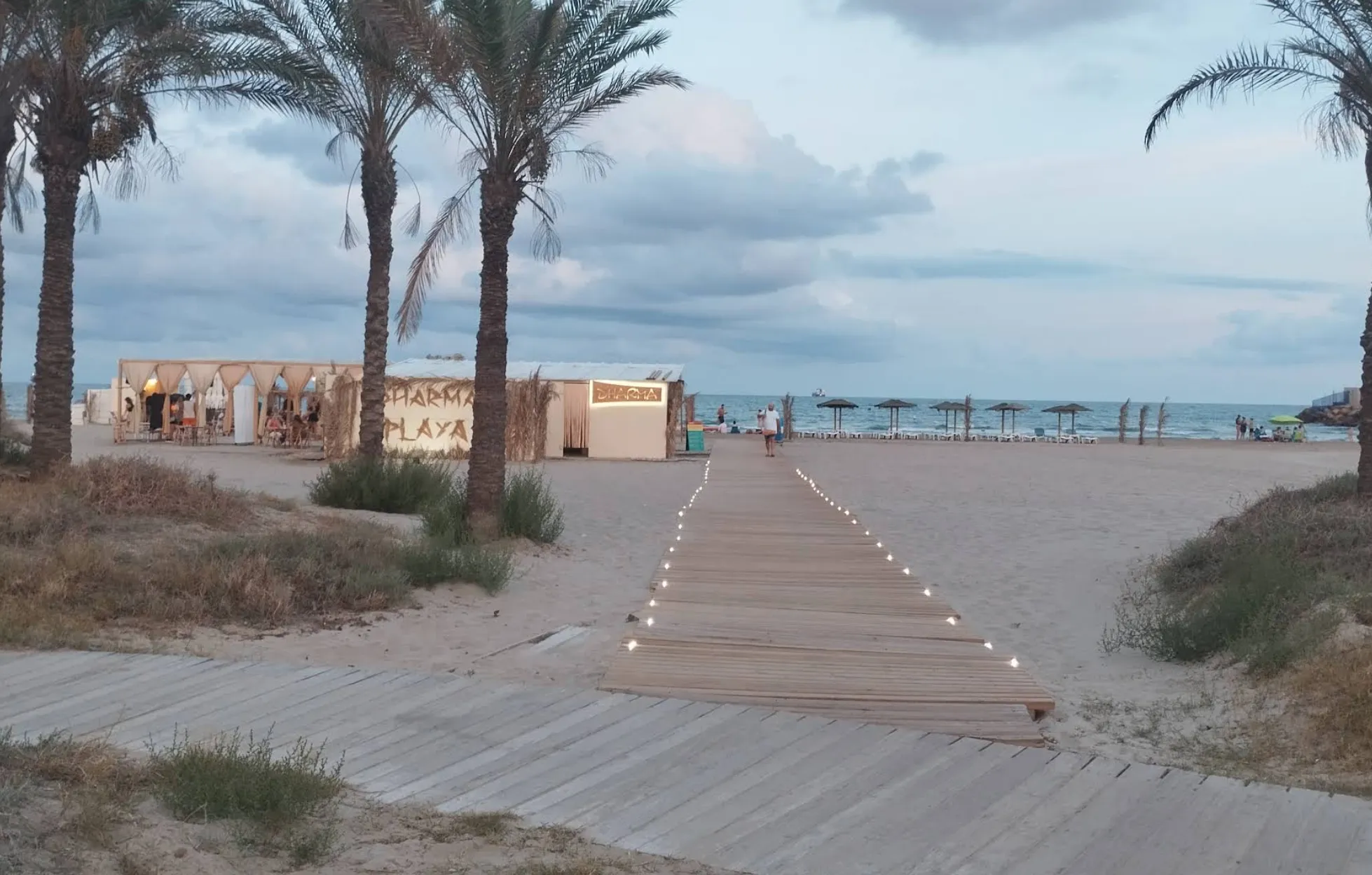 Beachfront terrace with hanging chairs at Dharma Beach Club on Playa del Pinar